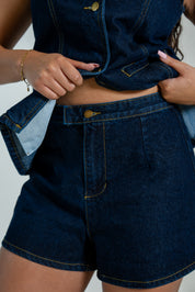 Women's sleeveless denim vest and high-waisted denim shorts set with gold button details.