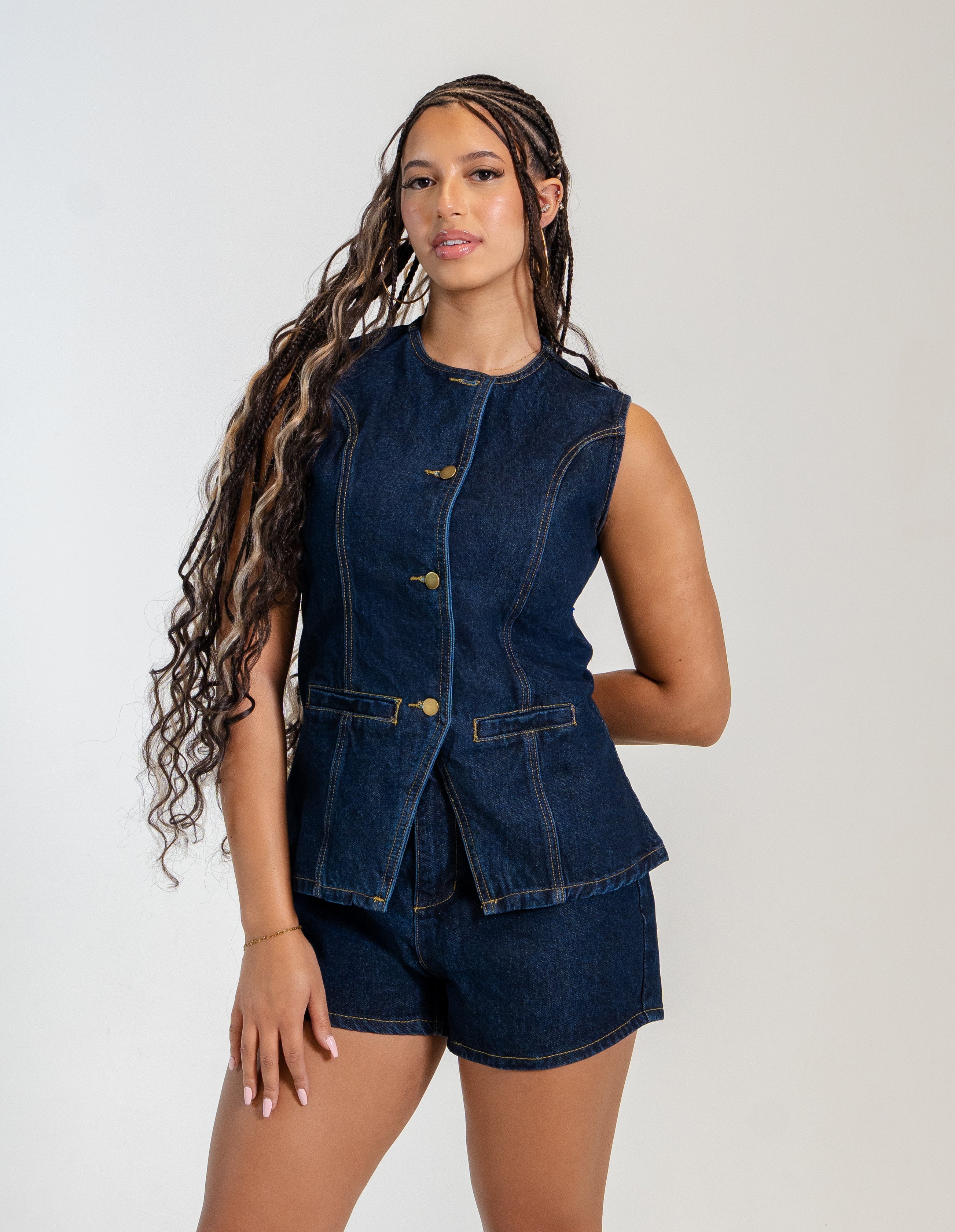 Women's sleeveless denim vest and high-waisted denim shorts set with gold button details.