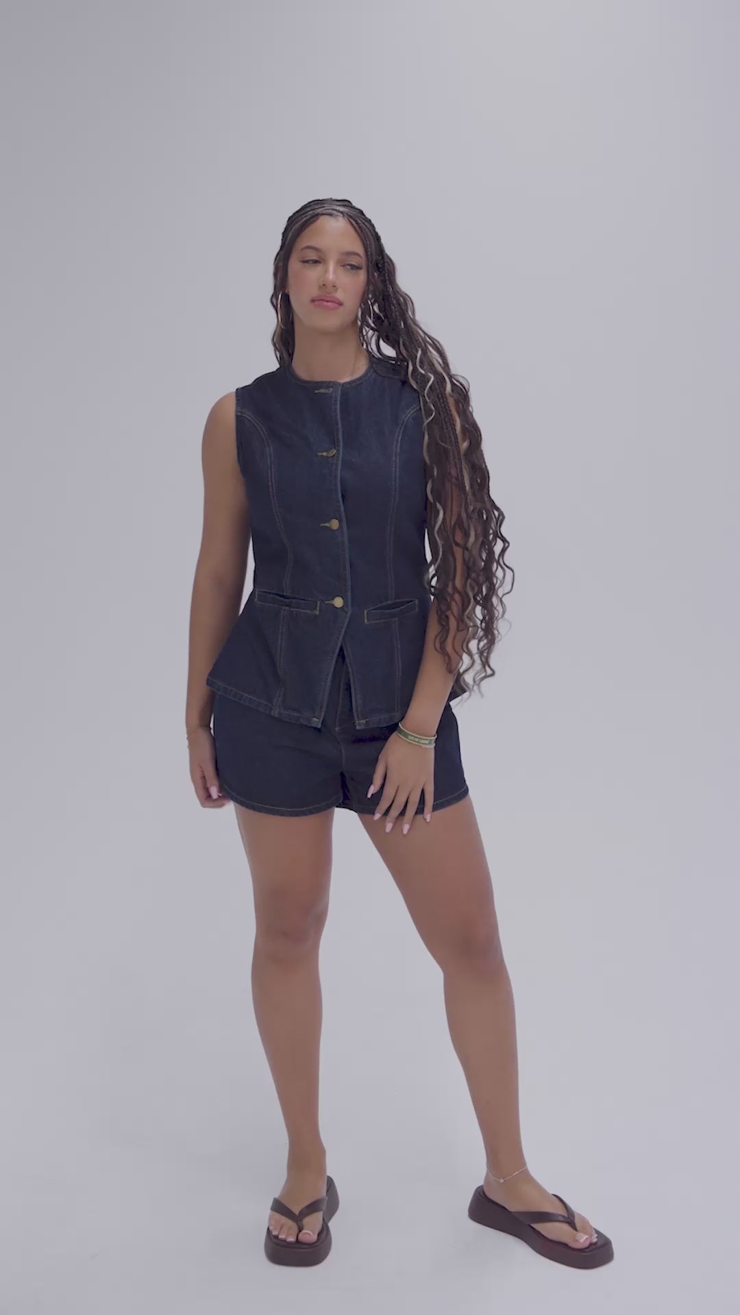 Women's sleeveless denim vest and high-waisted denim shorts set with gold button details.